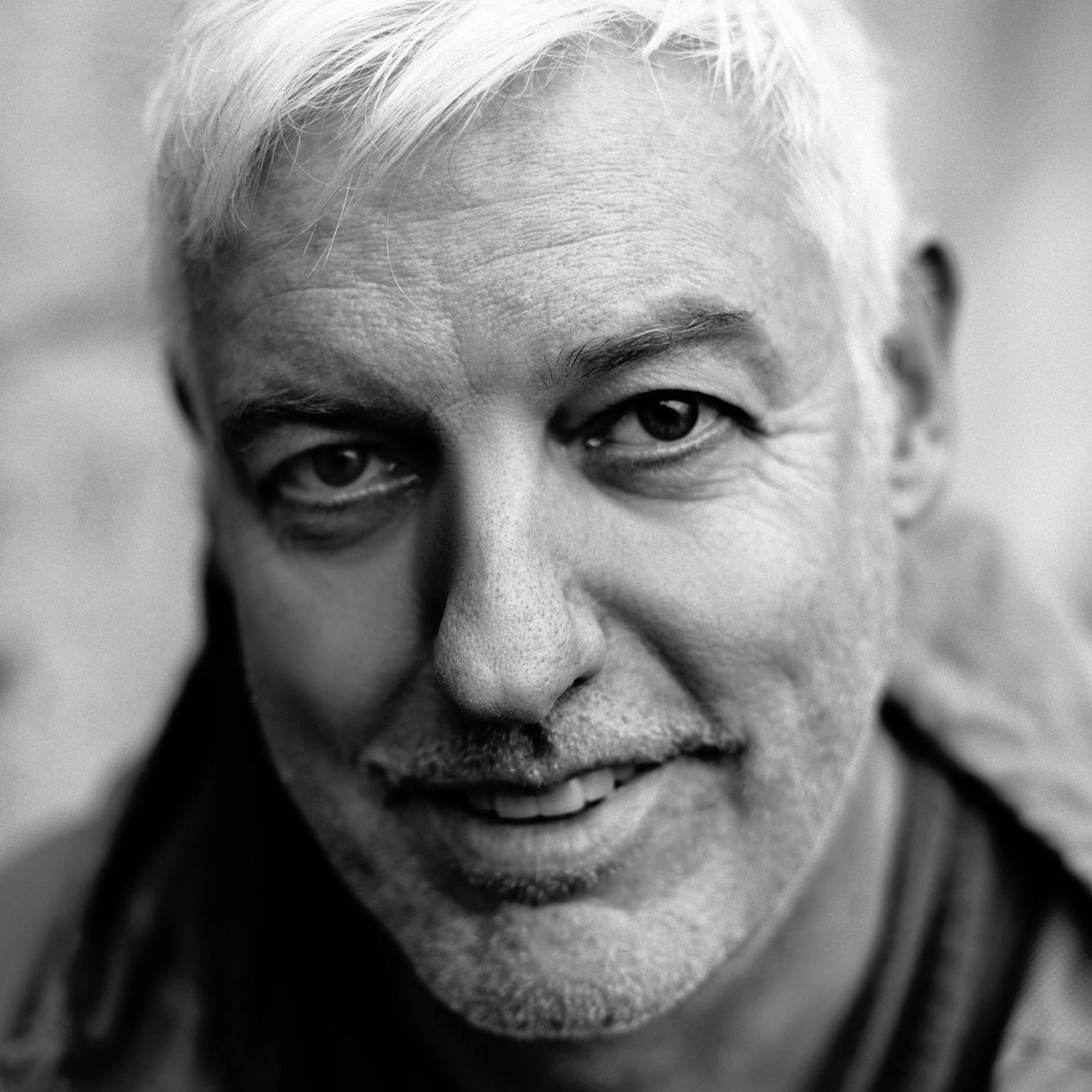 Schwarz-weißes Nahporträt von Raimund Verspohl mit weißem Haar, der direkt und aufmerksam in die Kamera blickt.
